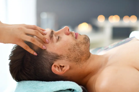 man happy to have a massage on hie forehead